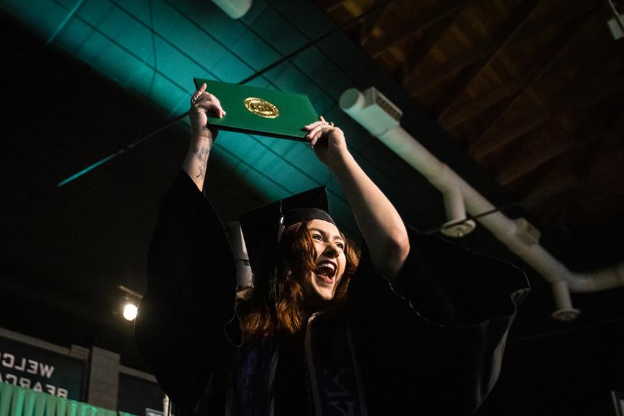 周六，<a href='http://salmonbayk8.getrealcuba.com'>全国网赌正规平台</a>的一名毕业生在毕业典礼上展示她的毕业证书.
